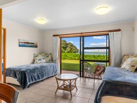 A living room with beds and a table at Mangawhai Marvel - Mangawhai Heads