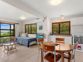 A living room with a bed and kitchen area at Mangawhai Marvel - Mangawhai Heads