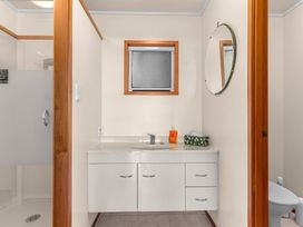 A bathroom with a sink and cabinet at Mangawhai Marvel - Mangawhai Heads
