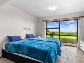 A bedroom with two beds and a window view at Mangawhai Marvel - Mangawhai Heads