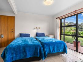 A bedroom with two beds and a window at Mangawhai Marvel - Mangawhai Heads