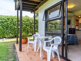 An outdoor area with a table and chairs at Mangawhai Marvel - Mangawhai Heads