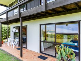An outdoor patio with chairs and a table at Mangawhai Marvel - Mangawhai Heads