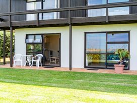 An outdoor area with a table and chairs at Mangawhai Marvel - Mangawhai Heads