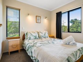 A bedroom with a bed and nightstand at Bayview Cottage - Whakamarama Holiday Home in Whakamarama