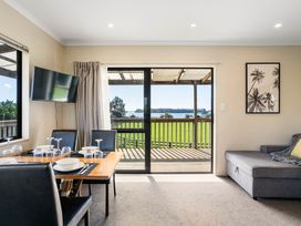 A dining room with a table and chairs at Bayview Cottage - Whakamarama