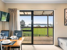 A dining room with a table and chairs at Bayview Cottage - Whakamarama