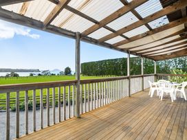 A deck with table and chairs at Bayview Cottage - Whakamarama