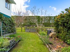 A garden with plants and a fence at Bayview Cottage - Whakamarama