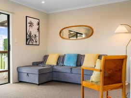 A living room with a sofa and chair at Bayview Cottage - Whakamarama