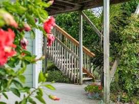 Stairs leading up from a pathway surrounded by plants and flowers at Bayview Cottage - Whakamarama