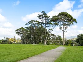 A park area with trees and a path at Bayview Cottage - Whakamarama