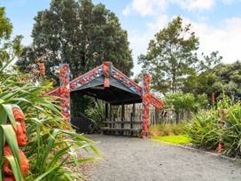 An outdoor entrance with carvings and a pathway at Bayview Cottage - Whakamarama Holiday Home