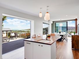 A kitchen with an island and seating at Raglan Holiday Home
