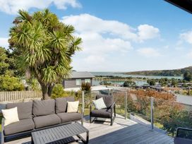An outdoor seating area with a view of water at Raglan Holiday Home