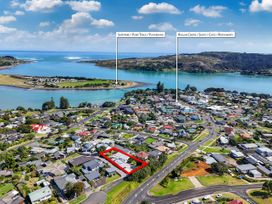 An aerial view of a residential area and river at Raglan Holiday Home 