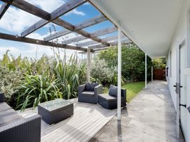 An outdoor area with seating and greenery at Raglan Holiday Home