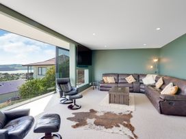 A living room with a sofa and coffee table at Raglan Holiday Home