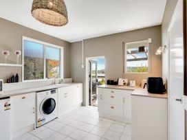 A kitchen with a washing machine and appliances at Raglan Holiday Home