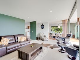 A living room with a sofa and coffee table at Raglan Holiday Home