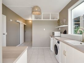 A laundry room with washing machine and dryer at Raglan Holiday Home