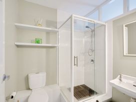 A bathroom with a shower, toilet, and sink at Raglan Holiday Home