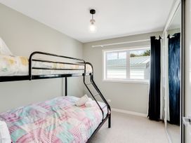 A bedroom with a bunk bed and window at Raglan Holiday Home