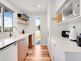 A kitchen with a sink and appliances at Raglan Holiday Home