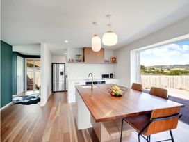 A kitchen with a refrigerator and kitchen island at Raglan Holiday Home