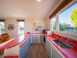A kitchen with sink, cabinets, and windows at Darling on Dorizac - Te Anau