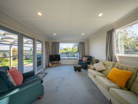 A living room with a sofa and television at Darling on Dorizac - Te Anau Holiday Home