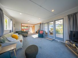 A living room with a sofa and television at Darling on Dorizac - Te Anau
