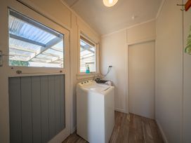 A laundry room with a washing machine and a window at Darling on Dorizac - Te Anau