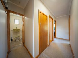 A hallway with doors and a bathroom at Darling on Dorizac - Te Anau