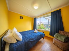 A bedroom with a bed and window at Darling on Dorizac - Te Anau Holiday Home