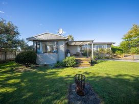 Exterior view of a house with a deck and garden at Darling on Dorizac - Te Anau Holiday Home, Te Anau