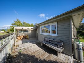 An outdoor area with a wooden deck and bench at Darling on Dorizac - Te Anau