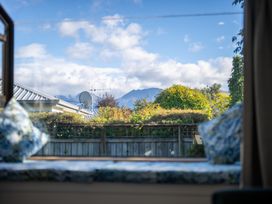 A view of mountains and trees from a window at Darling on Dorizac - Te Anau Holiday Home, Te Anau