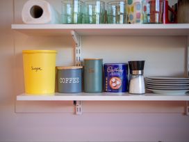 A kitchen shelf with containers and utensils at Darling on Dorizac - Te Anau Holiday Home