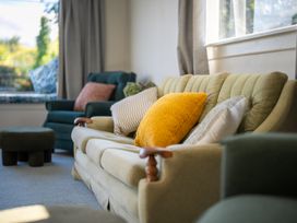 A living room with a sofa and cushions at Darling on Dorizac - Te Anau