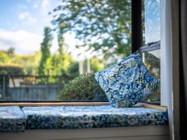 A window seat with cushions and an outdoor view at Darling on Dorizac - Te Anau