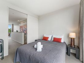 A bedroom with a bed and a bedside lamp at Lake Taupo Holiday Home in Taupo