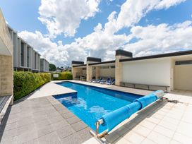 An outdoor area with a swimming pool and poolside chairs at Lake Taupo Holiday Home in Taupo