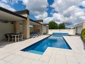 An outdoor area with a swimming pool and sun loungers at Lake Taupo Holiday Home Taupo
