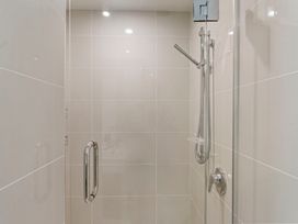 A shower with tiles and showerhead at Lake Taupo Holiday Home in Taupo