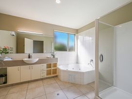 A bathroom with a bath tub and sink at Vintners - Renwick Holiday Home in Blenheim