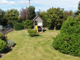 A garden with a playhouse and slide at Vintners - Renwick Holiday Home, Blenheim