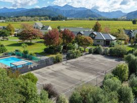An outdoor area with a swimming pool and tennis court at Vintners - Renwick Holiday Home, Blenheim