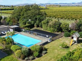 An outdoor area with a swimming pool and children's slide at Vintners - Renwick Holiday Home in Blenheim