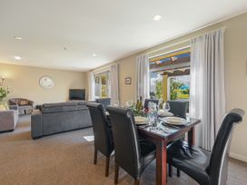 A living room with a dining area and television at Vintners - Renwick Holiday Home Blenheim